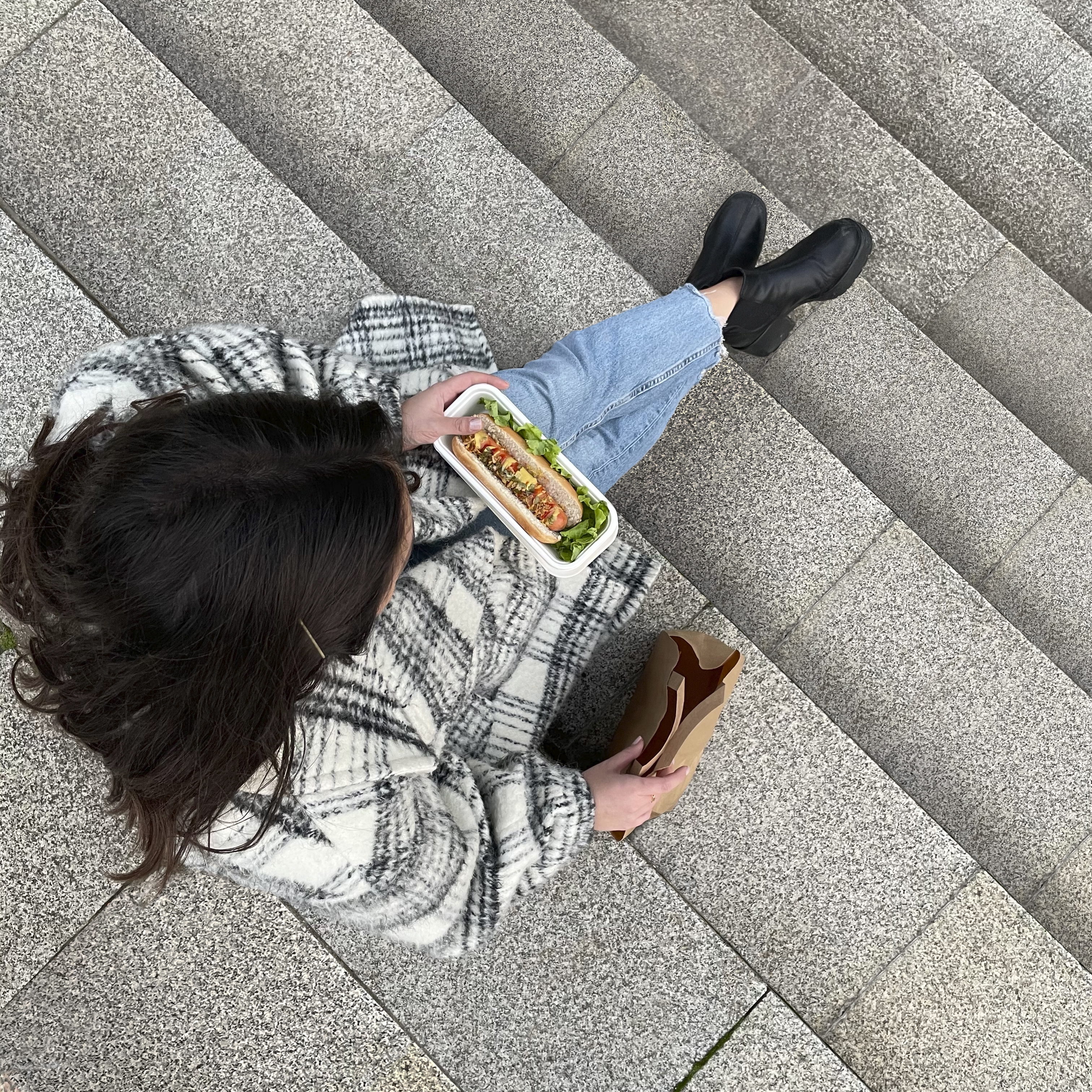 Girl sitting on steps with hot dog